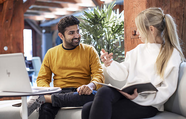 Mitarbeitende im Gespräch bei HHLA Next, der Innovationseinheit der HHLA, in einem modern gestalteten Besprechungsraum.