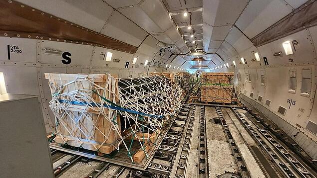 Stückgut wird im Frachtraum eines Flugzeugs befestigt.