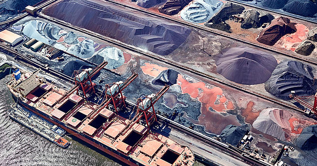 Aerial view of Hansaport in Hamburg with ore piles and ships – Germany’s largest ore and coal port with automated operations.