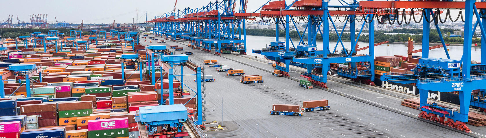 Automated AGVs move containers at HHLA Container Terminal Altenwerder in Hamburg – innovative, sustainable terminal with block storage and container cranes.