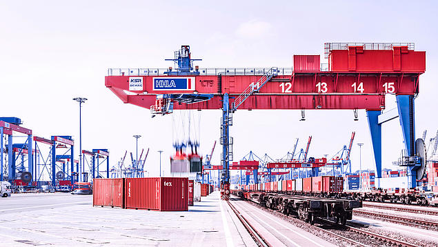 Blick auf den Bahnkran am HHLA Container Terminal Burchardkai, der Container auf Güterzüge im intermodalen Hinterlandverkehr verlädt.