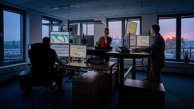 HHLA-Experten bei der Überwachung und Optimierung von Logistikabläufen an digitalen Leitständen.