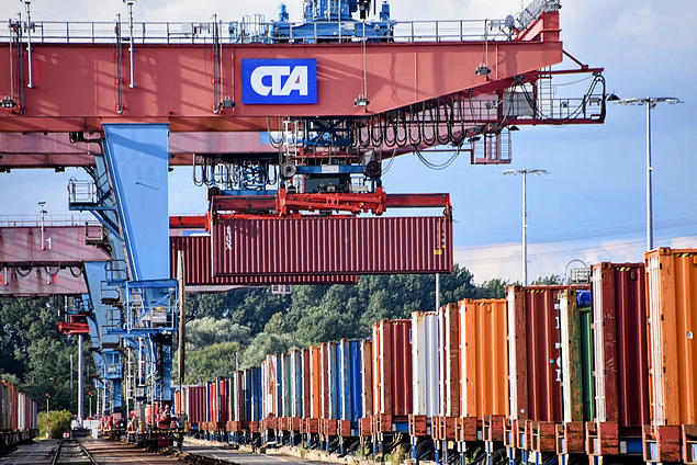 Rail crane at HHLA Container Terminal Altenwerder in Hamburg loads container onto freight train – eco-friendly handling at Europe’s largest rail port.